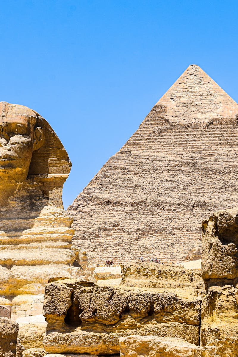 Magnificent view of the Great Sphinx and Pyramid of Khafre at Giza, Egypt under clear blue skies.
