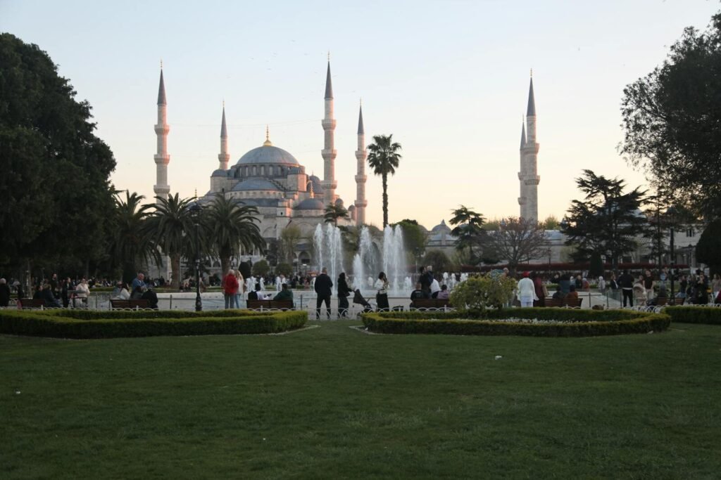 A beautiful view of the Blue Mosque in Istanbul during sunset with a lively park in the foreground.